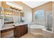 Luxurious bathroom with a soaking tub, glass block window, and tiled shower at 4080 Gevalia Dr, Brooksville, FL 34604