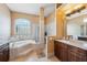 Luxurious bathroom featuring tiled floors, soaking tub, glass block window, and a glass shower at 4080 Gevalia Dr, Brooksville, FL 34604