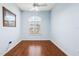 This bedroom features light blue walls, wood flooring, and a bright arched window with shutters at 4080 Gevalia Dr, Brooksville, FL 34604