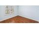 A corner of the bedroom with wood floors, light blue walls, white trim and a window with white shutters at 4080 Gevalia Dr, Brooksville, FL 34604