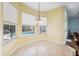 View of the breakfast nook featuring tile floors, yellow walls, large windows and backyard swimming pool at 4080 Gevalia Dr, Brooksville, FL 34604