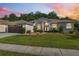 Charming single-story home with manicured lawn and well-maintained landscaping at sunset at 4080 Gevalia Dr, Brooksville, FL 34604