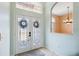 Inviting foyer with decorative glass doors, light tile flooring, and an arched window offering a glimpse into the adjacent room at 4080 Gevalia Dr, Brooksville, FL 34604