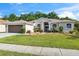 Inviting home featuring lush landscaping, a well-maintained lawn, and an arched entryway framed by decorative windows at 4080 Gevalia Dr, Brooksville, FL 34604