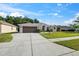 Charming single-story home with a well-manicured lawn and a spacious driveway leading to a two-car garage at 4080 Gevalia Dr, Brooksville, FL 34604