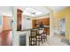 Bright kitchen with wooden cabinets, granite countertops, breakfast bar, and stainless steel wine cooler at 4080 Gevalia Dr, Brooksville, FL 34604