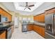 Bright kitchen featuring tile flooring, wood cabinets, granite counters, and modern stainless appliances at 4080 Gevalia Dr, Brooksville, FL 34604