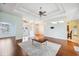 Open-concept living room with tray ceiling, hardwood floors, and abundant natural light at 4080 Gevalia Dr, Brooksville, FL 34604
