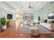 A furnished living room features wood floors, tray ceilings, light walls, and a striped area rug at 4080 Gevalia Dr, Brooksville, FL 34604