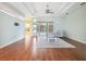 A serene living room featuring tray ceilings, light walls, and wood floors, bathed in natural light from the sliding doors at 4080 Gevalia Dr, Brooksville, FL 34604