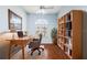 Home office featuring built-in bookshelves, hardwood flooring, and a comfortable workspace at 4080 Gevalia Dr, Brooksville, FL 34604