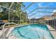 Inviting screened-in pool with clear blue water, patio area and lush landscaping at 4080 Gevalia Dr, Brooksville, FL 34604