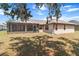 Exterior backyard view featuring a screened lanai, grass, and foliage at 4335 Duval St, Spring Hill, FL 34606