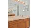 Large bathroom vanity with double mirrors and plenty of lighting, and oak cabinets at 4335 Duval St, Spring Hill, FL 34606