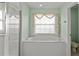 Bathroom featuring glass shower, large garden tub underneath a large window, and tile flooring at 4335 Duval St, Spring Hill, FL 34606