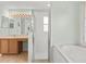Bathroom featuring tile floors, long vanity, glass enclosed shower, and soaking tub with tile surround at 4335 Duval St, Spring Hill, FL 34606