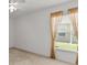 Bedroom featuring tan carpet, windows with tan drapes, and a ceiling fan at 4335 Duval St, Spring Hill, FL 34606