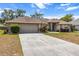 Inviting home exterior with a two-car garage, landscaped front yard, and a blue front door at 4335 Duval St, Spring Hill, FL 34606