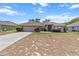 Charming single-story home featuring a lush lawn and front garden with stone accents and mature plantings at 4335 Duval St, Spring Hill, FL 34606