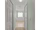 Hallway view leading to bathroom with a large window over the tub, and multiple white doors at 4335 Duval St, Spring Hill, FL 34606