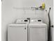 Laundry area with a washer, dryer, shelving and ironing board at 4335 Duval St, Spring Hill, FL 34606