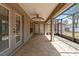 Covered back patio with tiled flooring, ceiling fan and views of the screened lanai and backyard at 4335 Duval St, Spring Hill, FL 34606