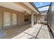 Spacious covered patio featuring neutral tiling, ceiling fan, and access to the home's interior through double doors at 4335 Duval St, Spring Hill, FL 34606