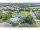 Aerial view showcases community amenities with a pool, clubhouse, tennis courts, and basketball court in a lush, residential neighborhood at 4500 Golf Club Ln, Spring Hill, FL 34609