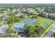 Aerial view showcases community amenities including a pool, clubhouse, tennis courts and basketball court in a lush neighborhood at 4500 Golf Club Ln, Spring Hill, FL 34609
