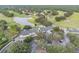 Aerial view of the community clubhouse, golf course, and serene pond surrounded by lush greenery at 4500 Golf Club Ln, Spring Hill, FL 34609