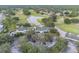 Aerial view of the community clubhouse, golf course, and serene pond surrounded by lush greenery at 4500 Golf Club Ln, Spring Hill, FL 34609