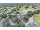 Aerial view of the community clubhouse, golf course, and serene pond surrounded by lush greenery at 4500 Golf Club Ln, Spring Hill, FL 34609