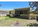 Home's backyard with a screened lanai, and well-maintained lawn at 4500 Golf Club Ln, Spring Hill, FL 34609