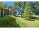 A serene backyard view featuring a lush green lawn, mature trees, and a glimpse of the golf course at 4500 Golf Club Ln, Spring Hill, FL 34609
