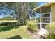 Backyard view of the screened-in lanai, well-manicured lawn and view of the golf course at 4500 Golf Club Ln, Spring Hill, FL 34609