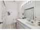 Clean bathroom featuring a single sink vanity, a large mirror, and a shower with decorative shower curtain at 4500 Golf Club Ln, Spring Hill, FL 34609