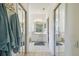 Bathroom with double sinks, neutral tiling, and mirrored closet doors at 4500 Golf Club Ln, Spring Hill, FL 34609