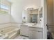 Bathroom with a soaking tub, natural light, and vanity sink at 4500 Golf Club Ln, Spring Hill, FL 34609