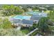 Aerial view of a community clubhouse with a large swimming pool and lush landscaping at 4500 Golf Club Ln, Spring Hill, FL 34609