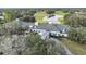 Aerial view of the community clubhouse surrounded by lush greenery, golf course, and serene pond at 4500 Golf Club Ln, Spring Hill, FL 34609
