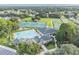 Aerial view of a community clubhouse and large swimming pool surrounded by landscaping and green space at 4500 Golf Club Ln, Spring Hill, FL 34609