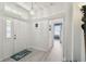 View of the bright entryway featuring light-colored hardwood floors and modern light fixtures at 4500 Golf Club Ln, Spring Hill, FL 34609