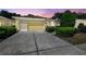Charming single-story home with a well-maintained lawn and a two-car garage under a colorful sunset at 4500 Golf Club Ln, Spring Hill, FL 34609