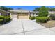 Inviting single-story home featuring a neatly manicured lawn, an attached two-car garage, and charming curb appeal at 4500 Golf Club Ln, Spring Hill, FL 34609