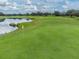 Scenic view of the golf course featuring a lush green with a water hazard and surrounding landscape at 4500 Golf Club Ln, Spring Hill, FL 34609