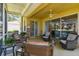 Comfortable screened lanai with ceiling fan and multiple seating options for outdoor enjoyment at 4500 Golf Club Ln, Spring Hill, FL 34609