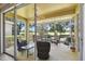 Covered and screened lanai featuring outdoor seating and a view of the lush green golf course at 4500 Golf Club Ln, Spring Hill, FL 34609
