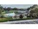 Aerial view showcasing the community pool, clubhouse, tennis courts, and surrounding green spaces at 4500 Golf Club Ln, Spring Hill, FL 34609