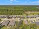 Aerial view of several homes and mature trees in a quiet residential neighborhood surrounded by lush foliage at 4910 Southern Valley Loop, Brooksville, FL 34601