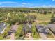 Aerial view of homes backing up to a golf course and mature trees in a quiet residential neighborhood at 4910 Southern Valley Loop, Brooksville, FL 34601